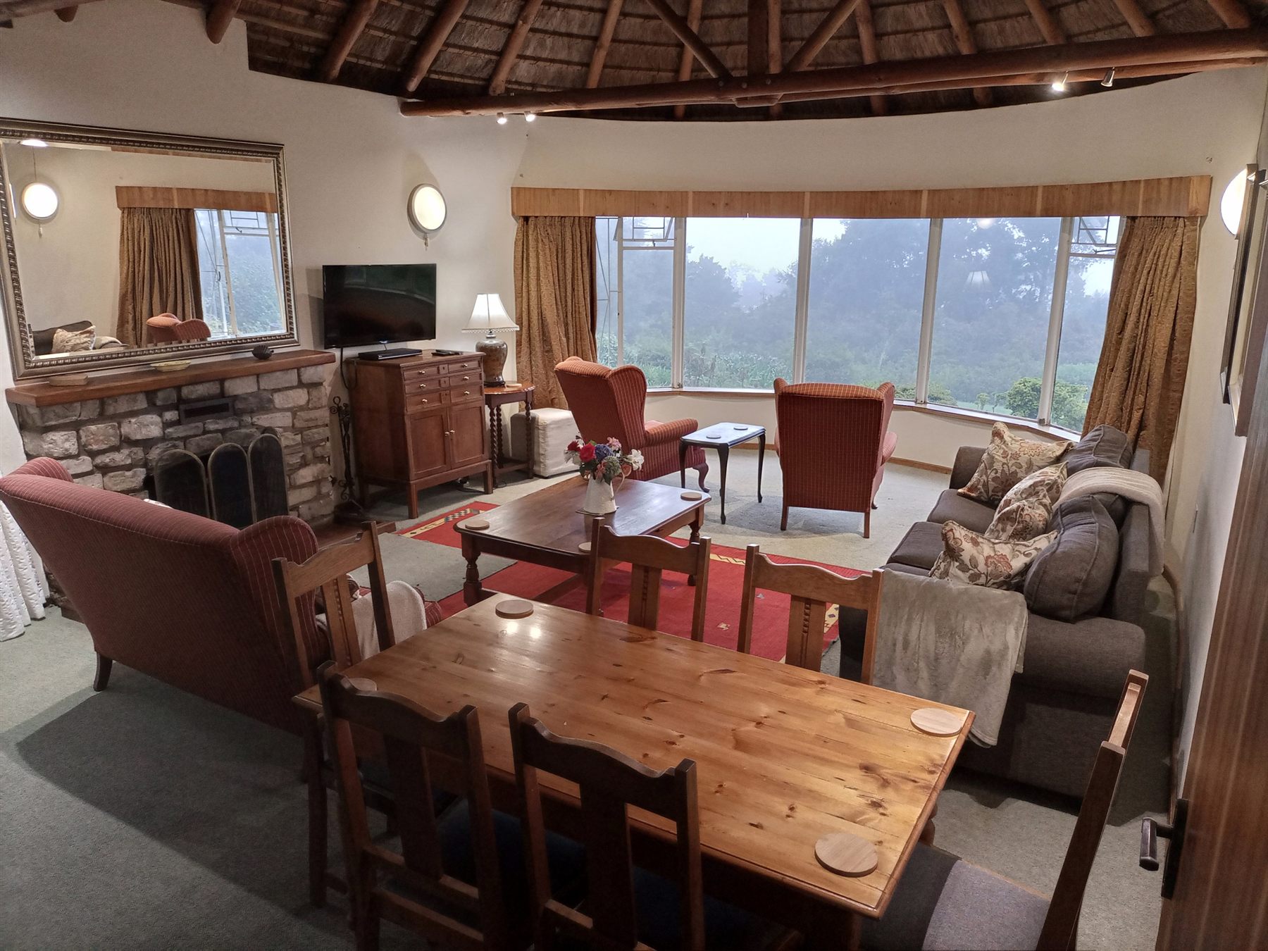 The Main House lounge and dining area beneath the thatch roof